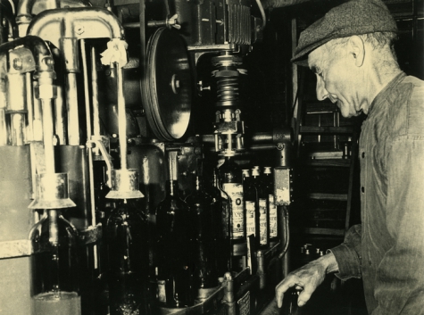 Robert Waeytens bij de flessenvulmachine, stokerij Van Damme, Balegem, ca. 1978