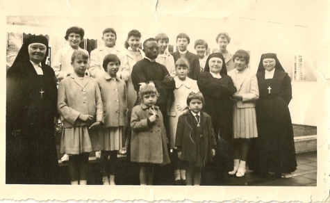Groepsfoto met zusters en een onbekende zwarte pater, Sint-Lievens-Houtem, 1955