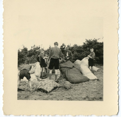 Chiro Melle vult strozakken op kamp, Genk, 1957