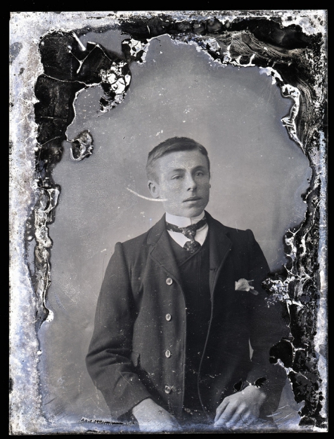 zittend borstportret van jonge man in kostuum met wit hemd en stropdas, naar achter gekamd haar en haarscheiding aan linkerkant, Melle , 1910-1920