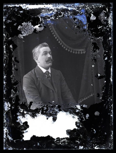 Zittend portret van man in kostuum met wit hemd en stropdas, gemodelleerde snor en kuifvormig gekamd haar, Melle , 1910-1920