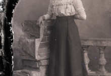 Rechtstaande jonge vrouw met lange rok, opgesmukte blouse, lange halsketting, Melle, 1910-1920