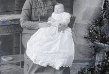 Zittend portret, jonge vrouw met opgestoken haar, halsketting, met baby op de schoot, Melle, 1910-1920