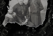 Foto van zittende moeder in feestkledij met lange halsketting, 2 jonge tienerdochters met lang haar en opgespelde strik, Melle , 1910-1920
