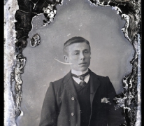 zittend borstportret van jonge man in kostuum met wit hemd en stropdas, naar achter gekamd haar en haarscheiding aan linkerkant, Melle , 1910-1920
